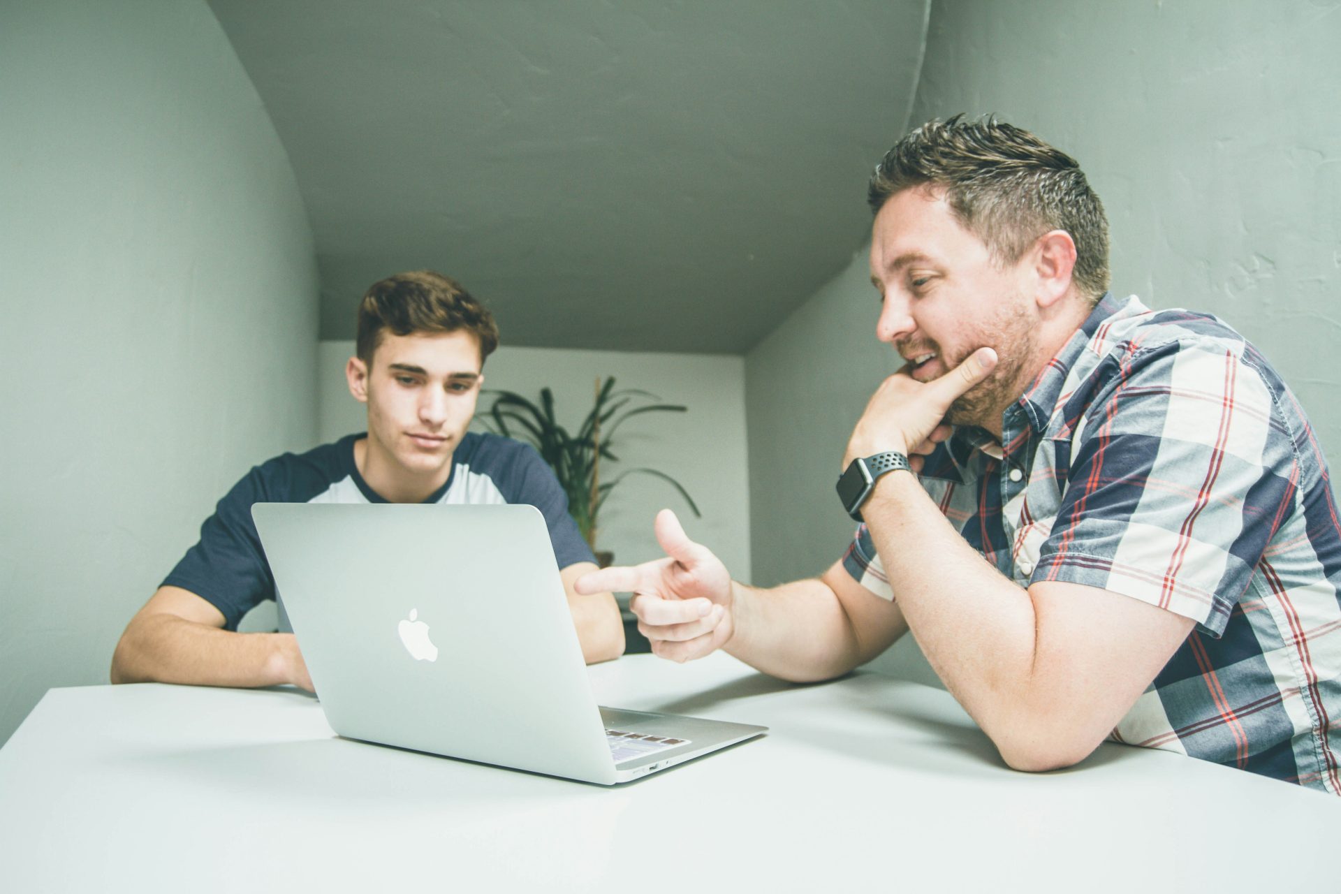 Two people having a discussion with a laptop