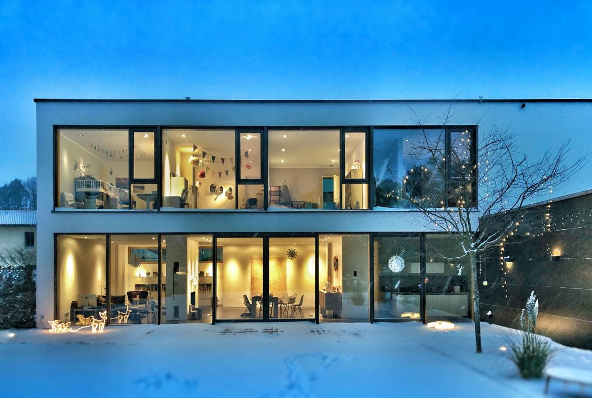 Modern house with large windows, lit at night