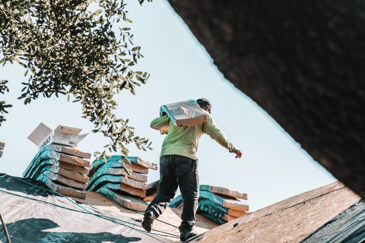 Person carrying materials on a rooftop.